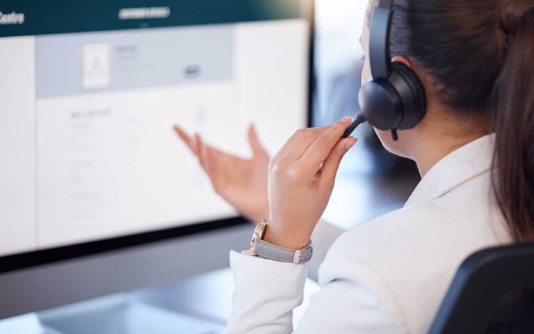 Adult family members review a life insurance policy and beneficiary forms at a kitchen table.